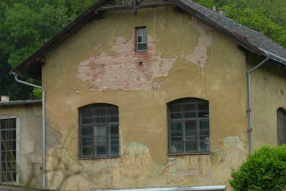 The exterior of an outdated home with peeling paint and dirty windows. The remaining paint is a dingy yellow color.